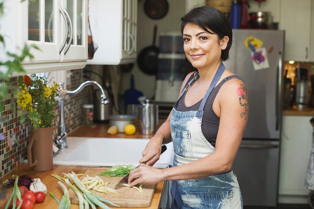 Jasmine Shimoda chops vegetables in her kitchen 