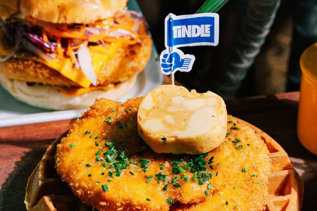 Photo shows an open-face sandwich topped with a vegan chicken patty made by the brand Tindle